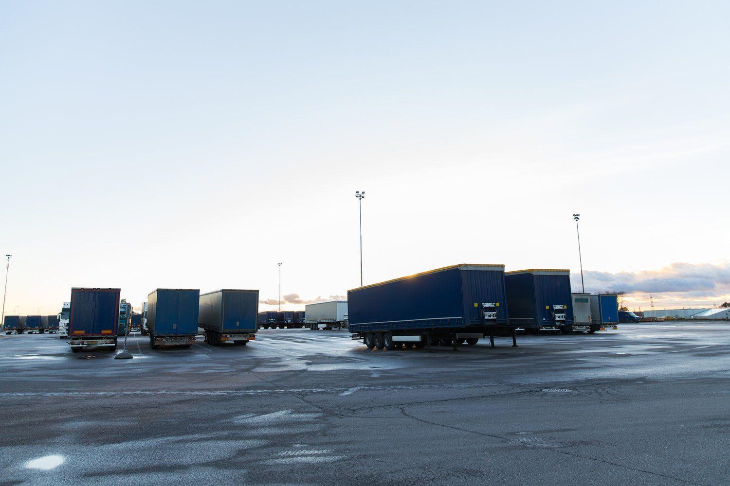 Ciągnik siodłowy z naczepą na placu małej firmy transportowej o zmierzchu